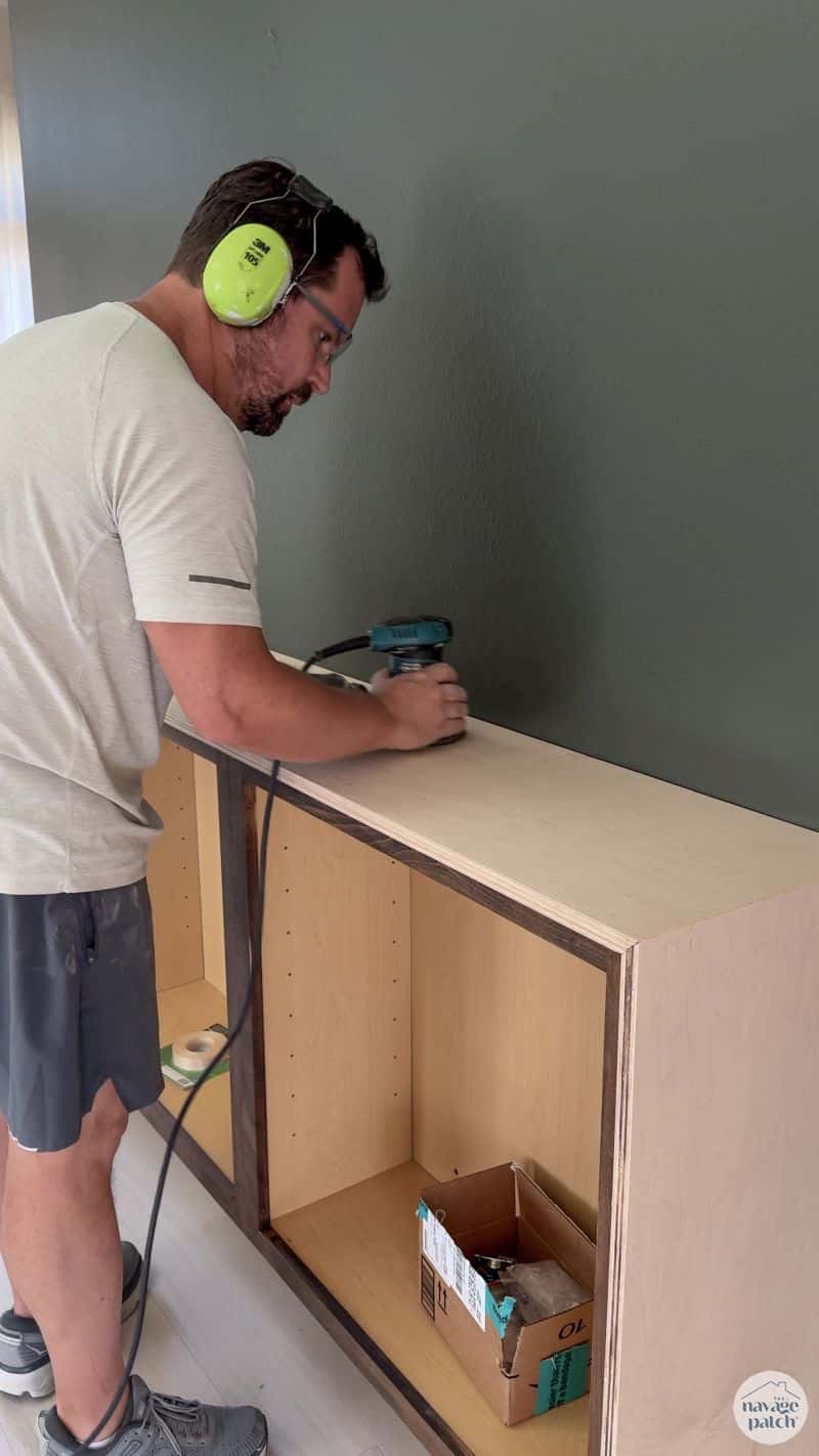 man sanding a console table