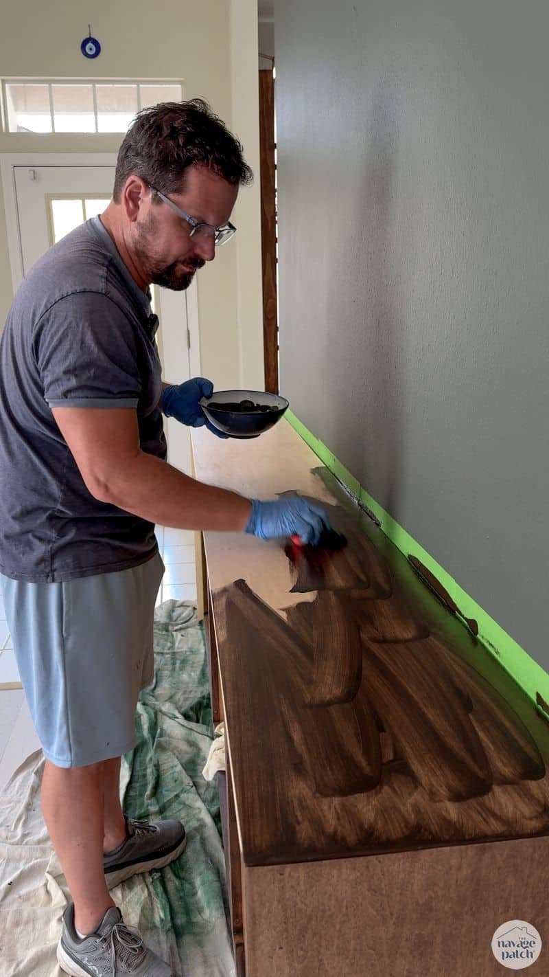 man staining a console table