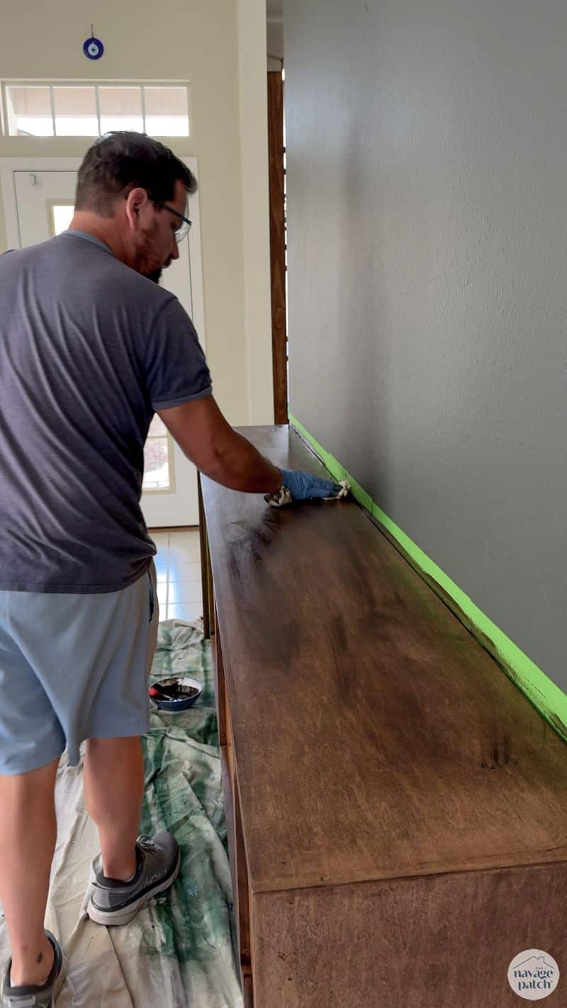 man staining a console table